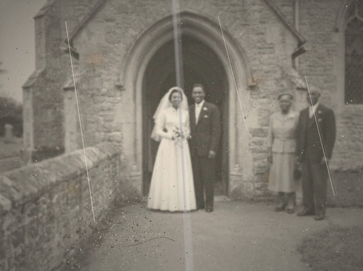 A black and white photograph from 1952 of a bride and groom in a church doorway, with her parents standing to one side.