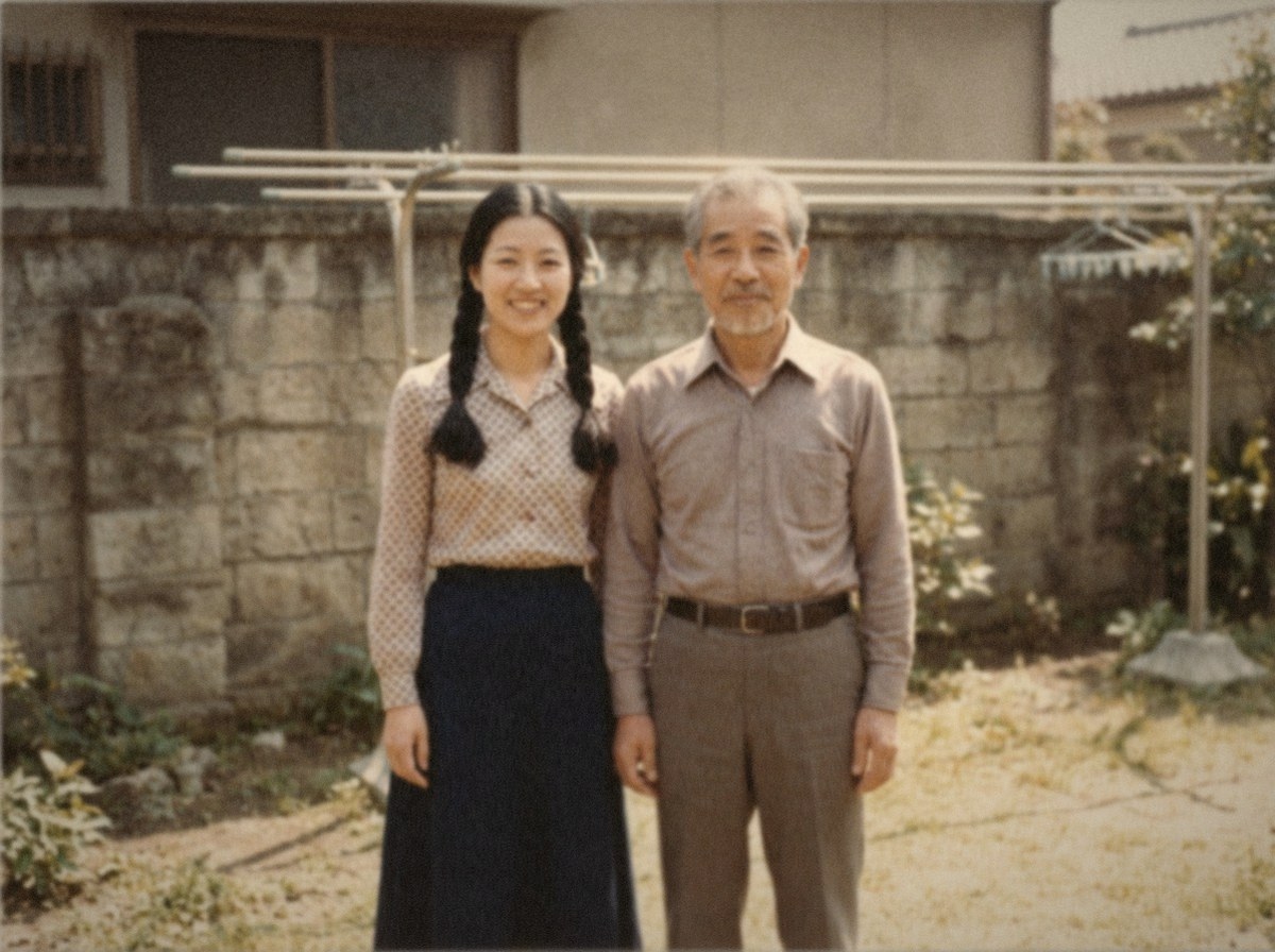 A photograph from 1975 of a woman and her father standing together in a garden.