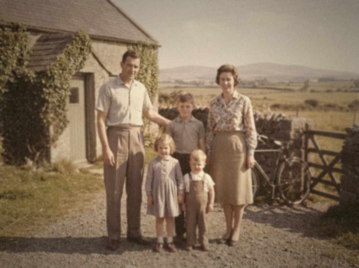 A colour photograph from 1962 of a family of five standing outside the front door of a small stone cottage.